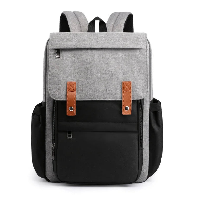 Modern two-tone gray and black backpack with brown strap accents and multiple zippered pockets