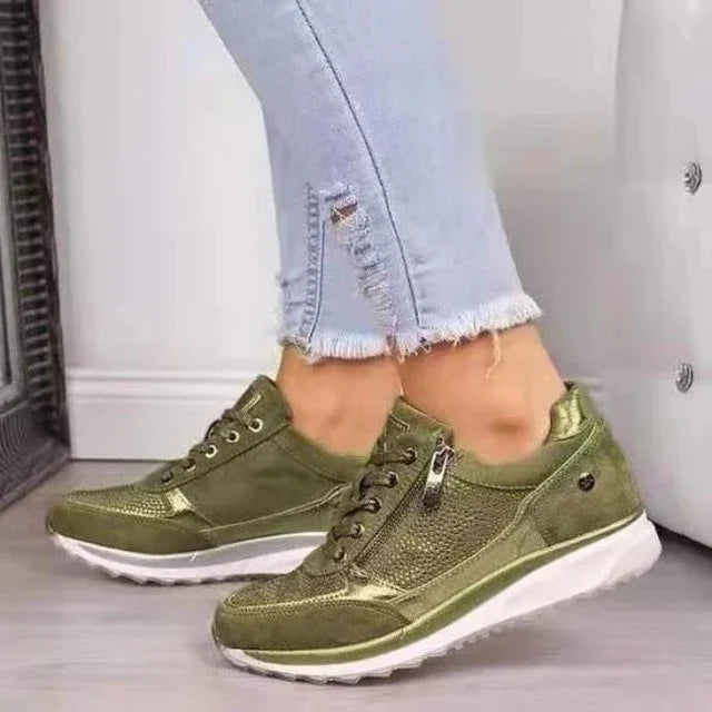Close-up of green casual sneakers with zipper detail worn with light blue frayed hem jeans