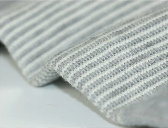 Close-up of soft grey and white striped knit fabric, cozy textile texture