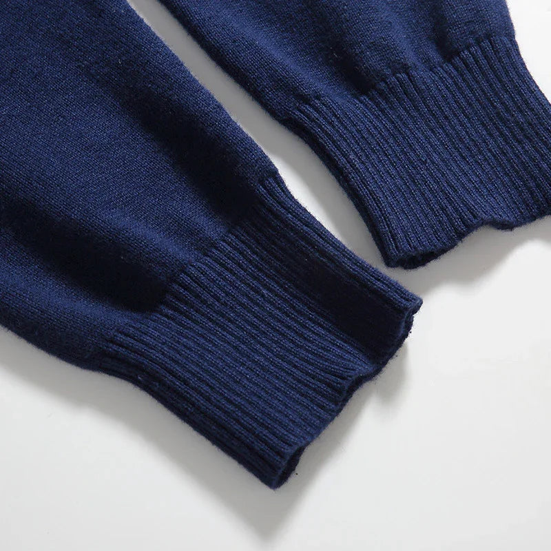 Close-up of ribbed cuffs on a navy blue knitted sweater, showcasing soft fabric texture