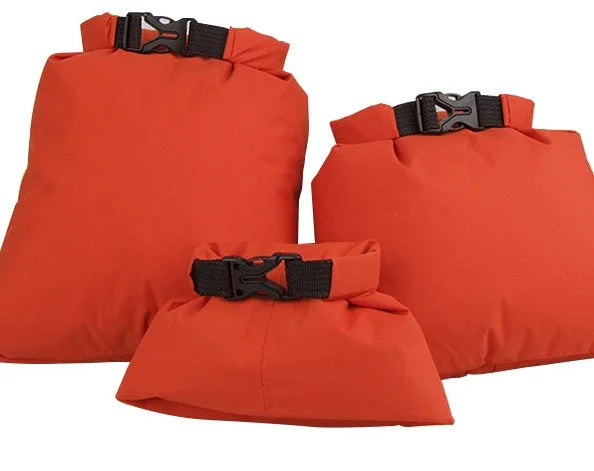 Three orange waterproof dry bags with black buckles on a white background.