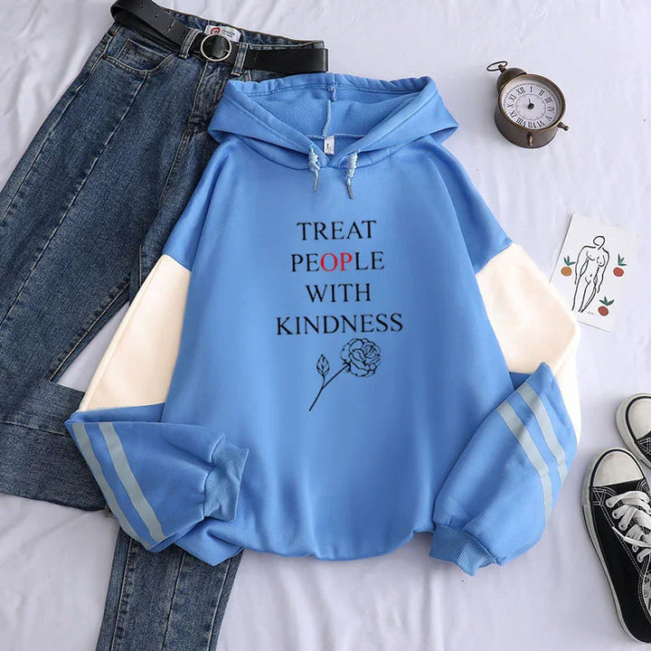 Blue hoodie with white sleeves and text Treat People With Kindness, paired with jeans, black belt, clock, and sneakers