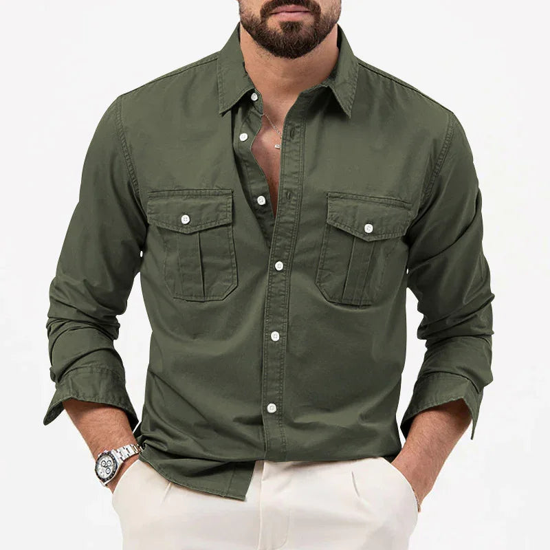 Man wearing olive green button-up shirt with two chest pockets and rolled sleeves, paired with light beige pants