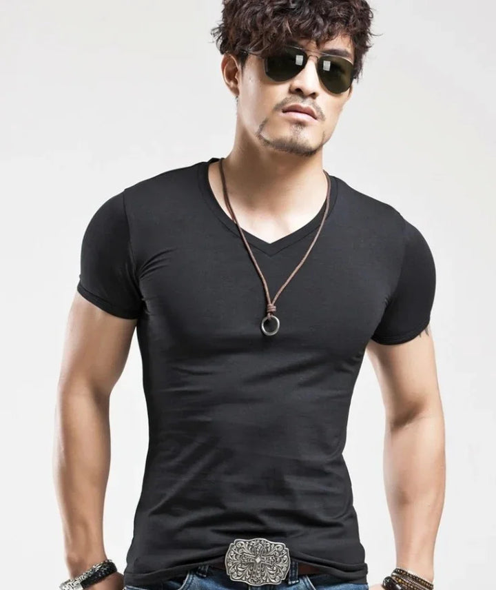 man wearing fitted black V-neck T-shirt, sunglasses, leather necklace, and decorative belt buckle