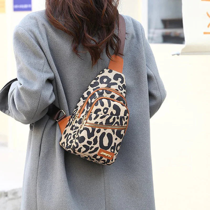 Person wearing gray coat and leopard print crossbody sling bag with brown accents