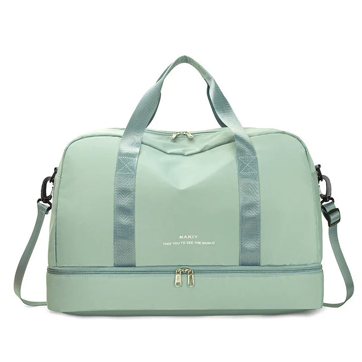 Light green travel duffel bag with double handles, shoulder strap, and bottom zipper compartment