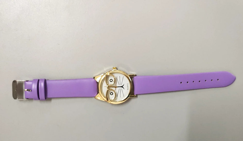 Purple wristwatch with cat face design and gold glasses frame on white background
