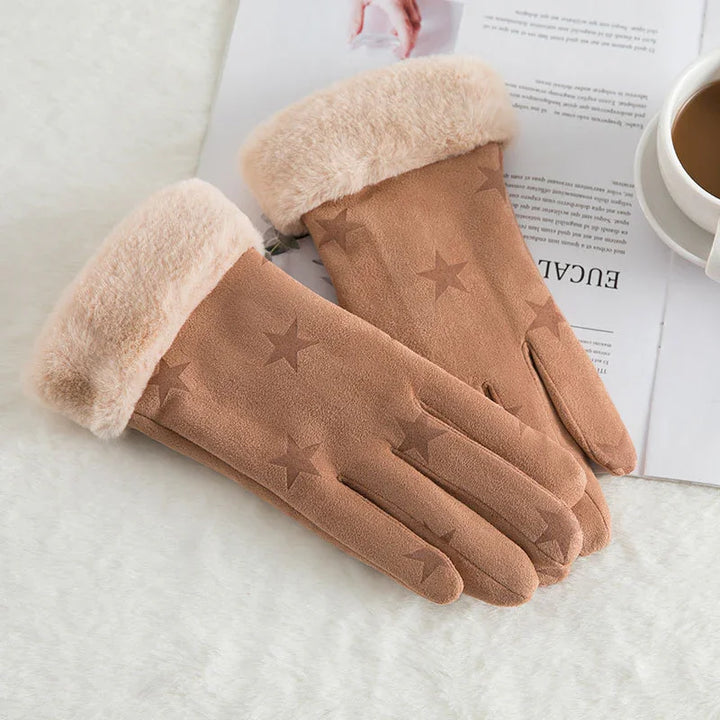 brown winter gloves with star pattern and soft fur cuffs on white surface next to coffee cup