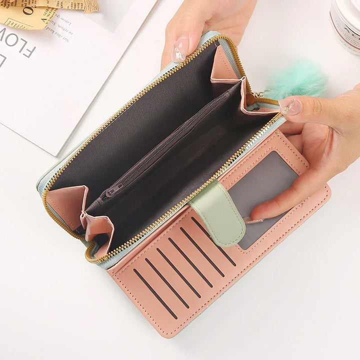 Pink and green leather wallet with multiple card slots, a transparent ID window, and a zippered main compartment held open