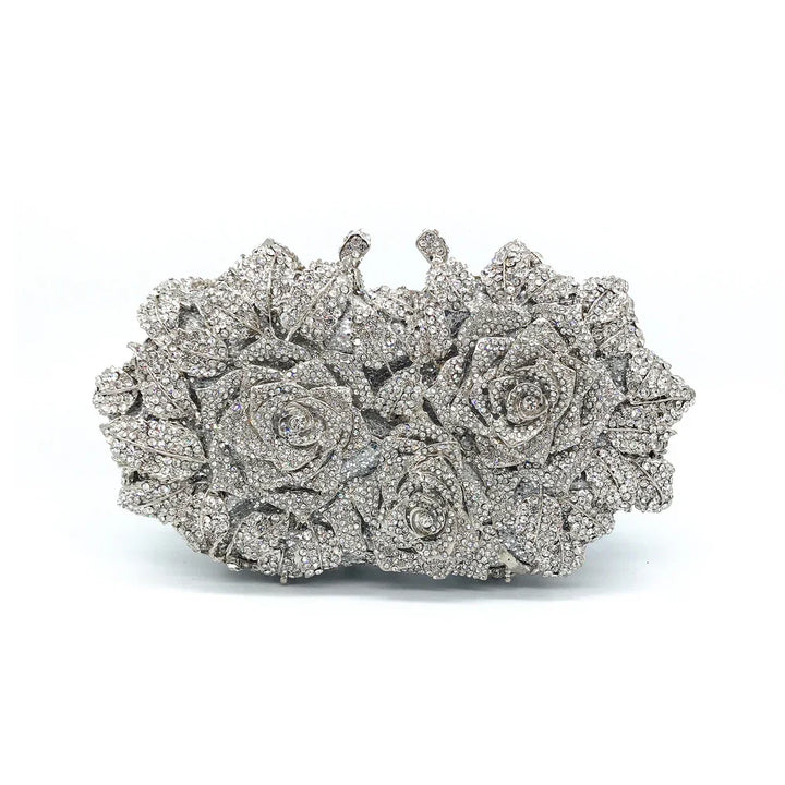 Silver rhinestone clutch bag with intricate rose and leaf design on white background