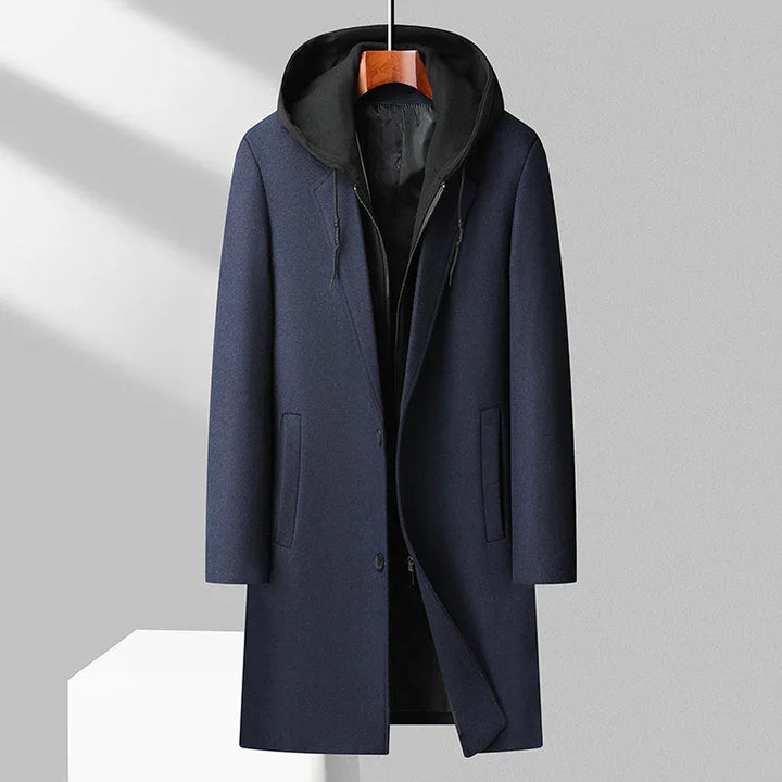 modern navy blue men's wool coat with black hood and drawstrings hanging on wooden hanger