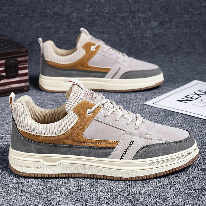 Casual men's sneakers with beige, brown, and gray suede panels on carpeted floor