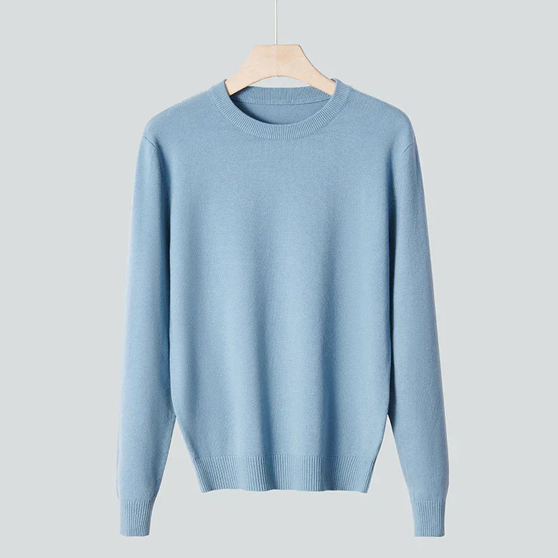 Light blue crew neck sweater hanging on wooden hanger against gray background