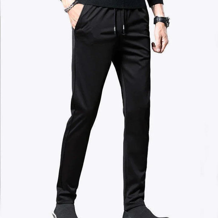 Mens slim fit black jogger pants with side pockets and drawstring waist styled with black sweater