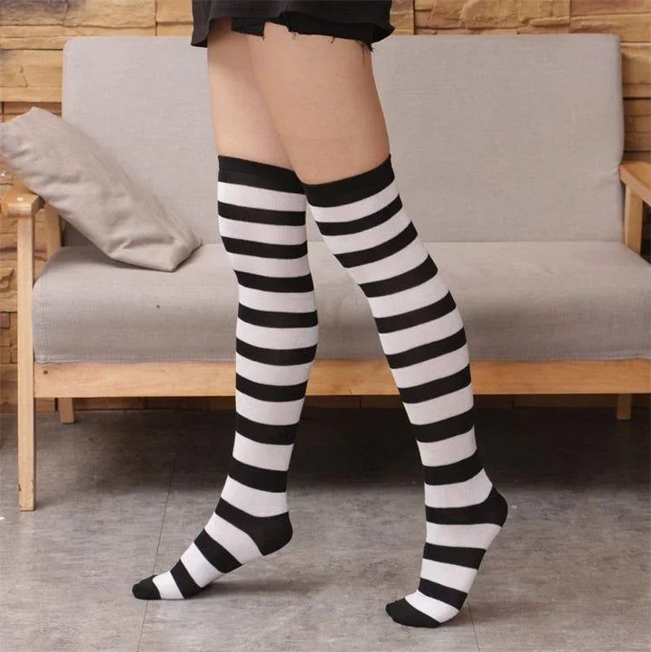 Person wearing black and white striped knee-high socks standing on tiled floor in living room