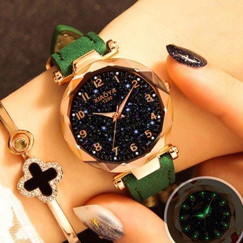 Elegant women's wristwatch with sparkling black starry dial and green leather strap on wrist