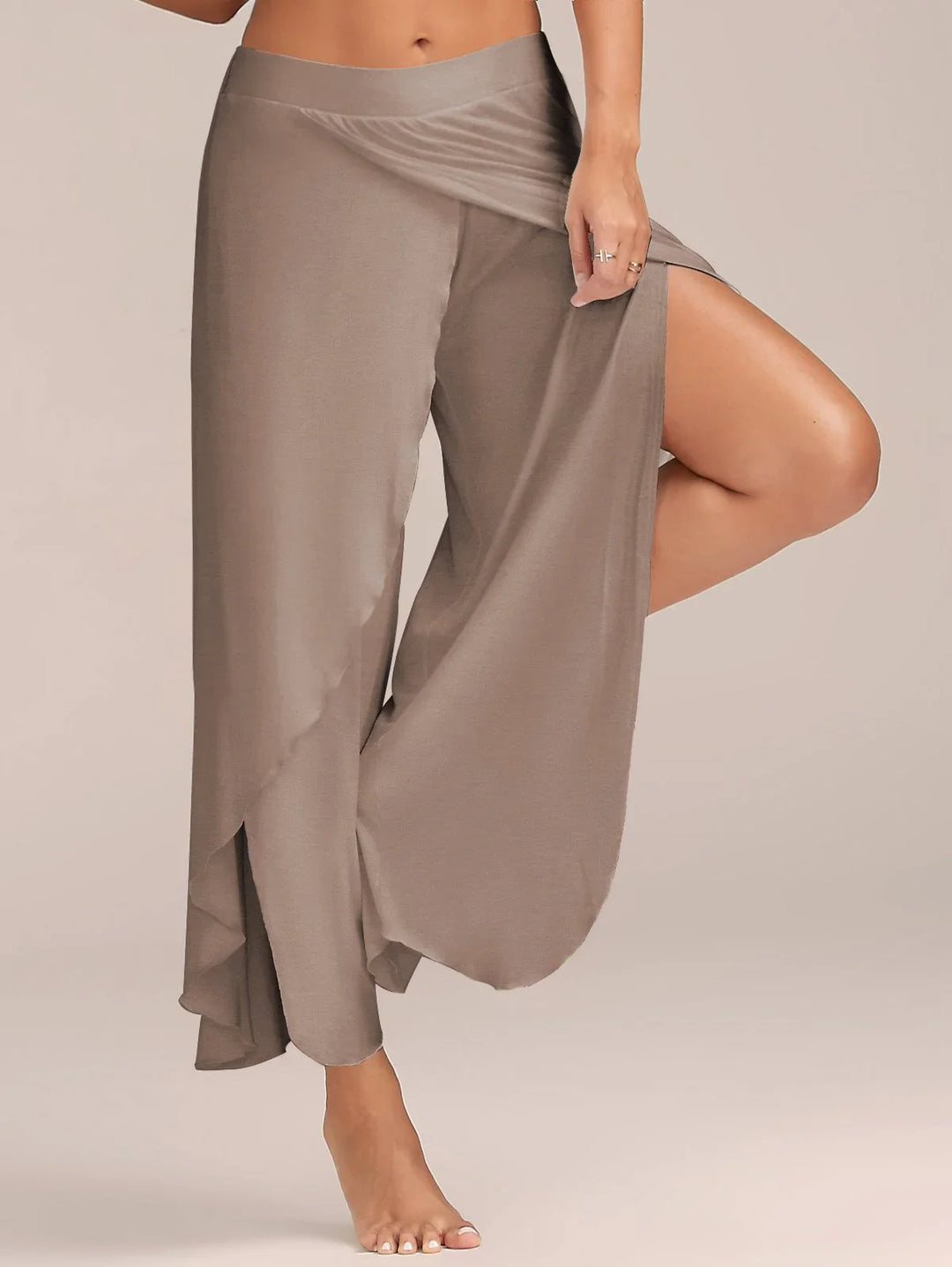 Woman wearing taupe wide-leg pants with side slit and overlay detail, posing barefoot