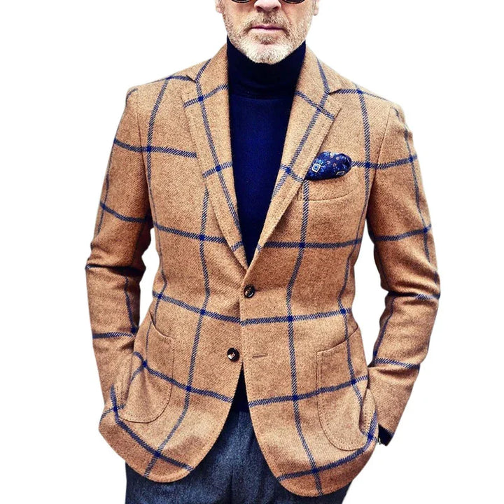 Man wearing camel brown plaid blazer with navy windowpane pattern, navy turtleneck, and pocket square