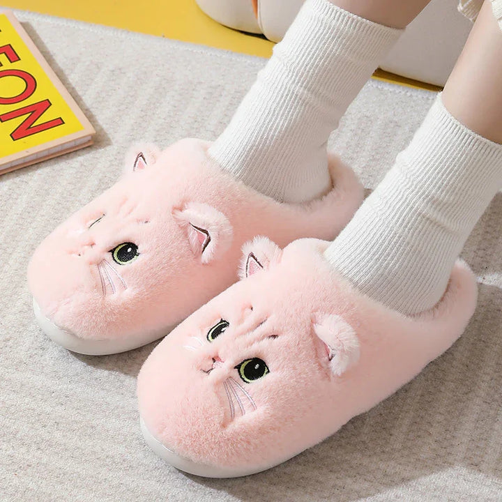 Person wearing soft pink plush cat slippers with white socks on a gray carpet