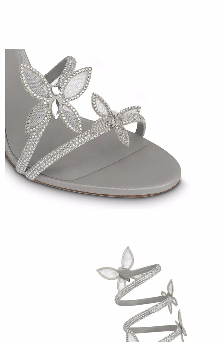 Elegant silver strappy sandal adorned with crystal butterfly embellishments and wraparound design