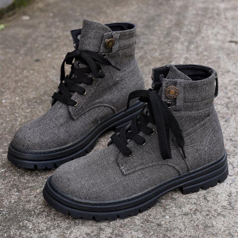 Gray fabric high-top boots with black laces and rugged black soles on concrete surface
