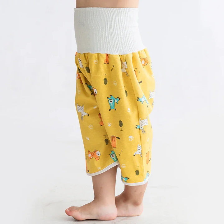 Child wearing yellow pants with colorful animal prints and white elastic waistband barefoot