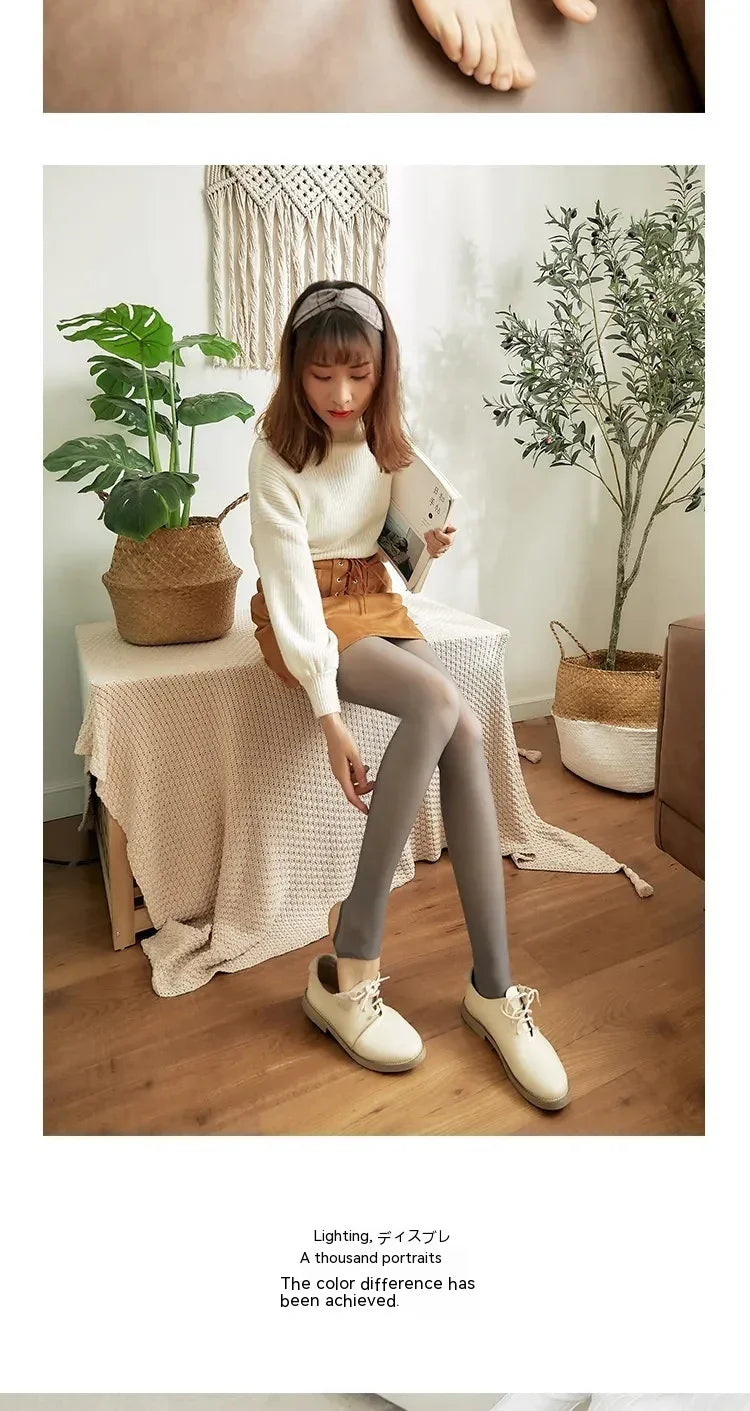Woman sitting indoors on a fabric-covered bench, wearing gray tights, white sweater, tan skirt, and white shoes, holding a book