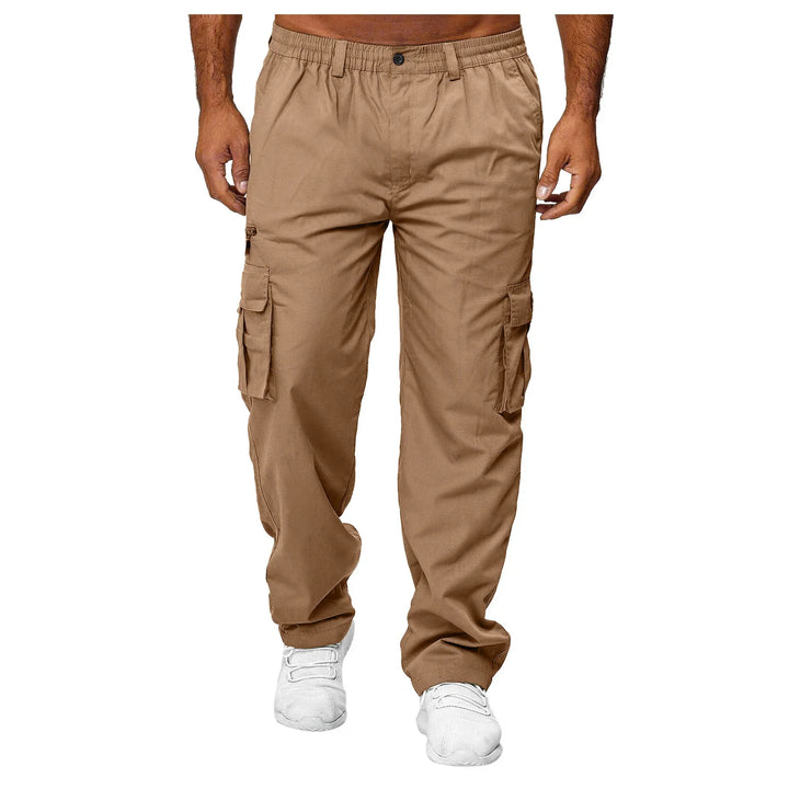 Men's tan cargo pants with multiple pockets and elastic waistband, paired with white sneakers