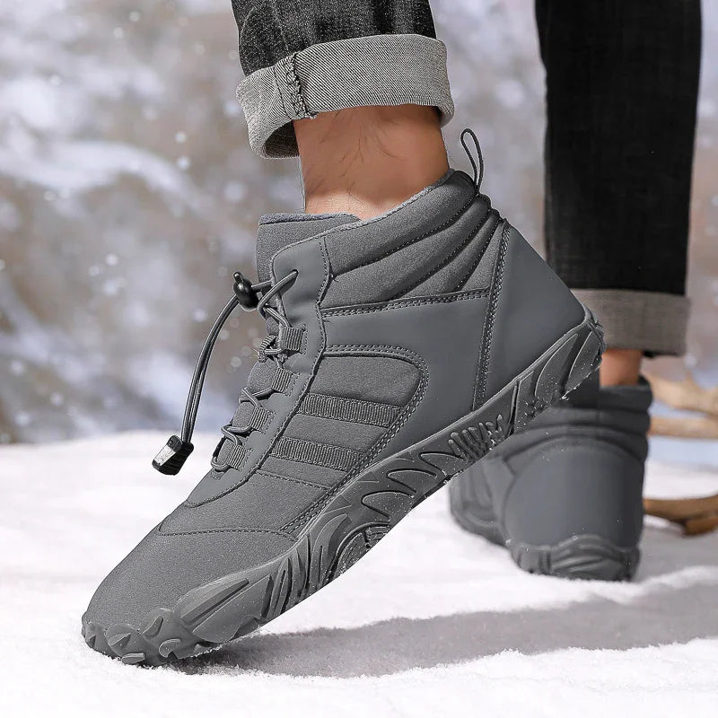 Stylish gray winter boots with rugged soles worn with rolled-up jeans in snowy outdoor setting