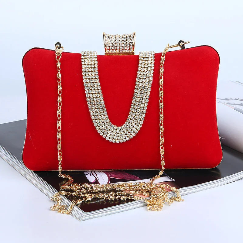 Red velvet clutch bag with gold chain and rhinestone embellishment on magazine