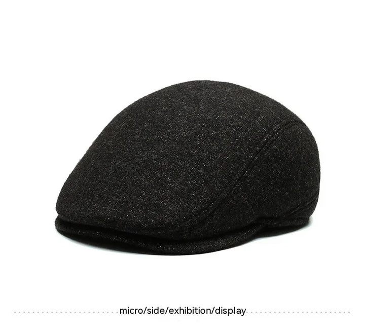 black flat cap hat with rounded shape and textured fabric on white background