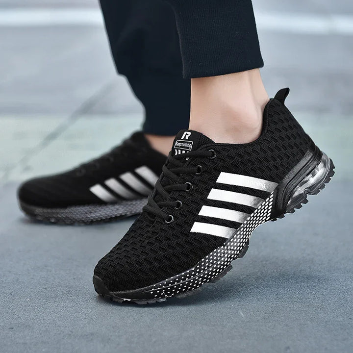 Black breathable mesh running shoes with white stripes and dotted sole on feet
