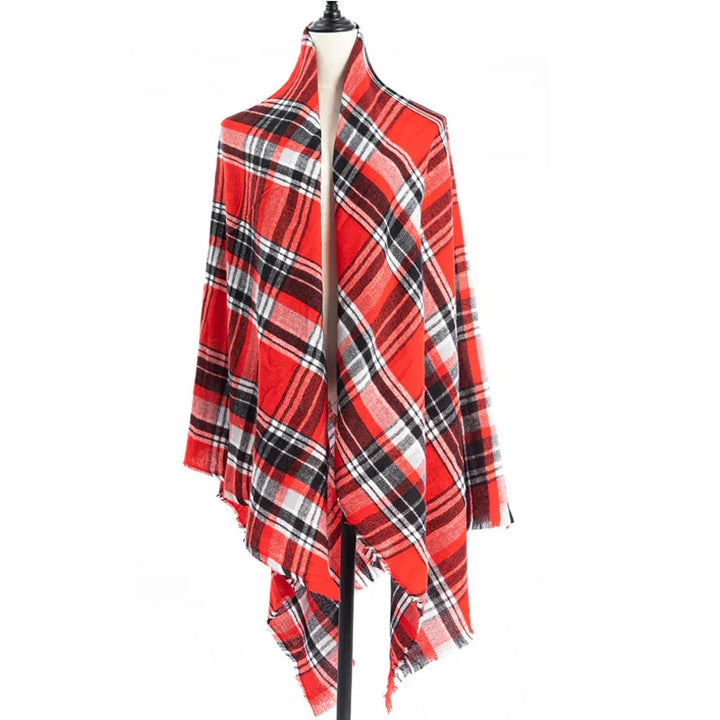 Red and black plaid shawl draped on dress form mannequin against white background