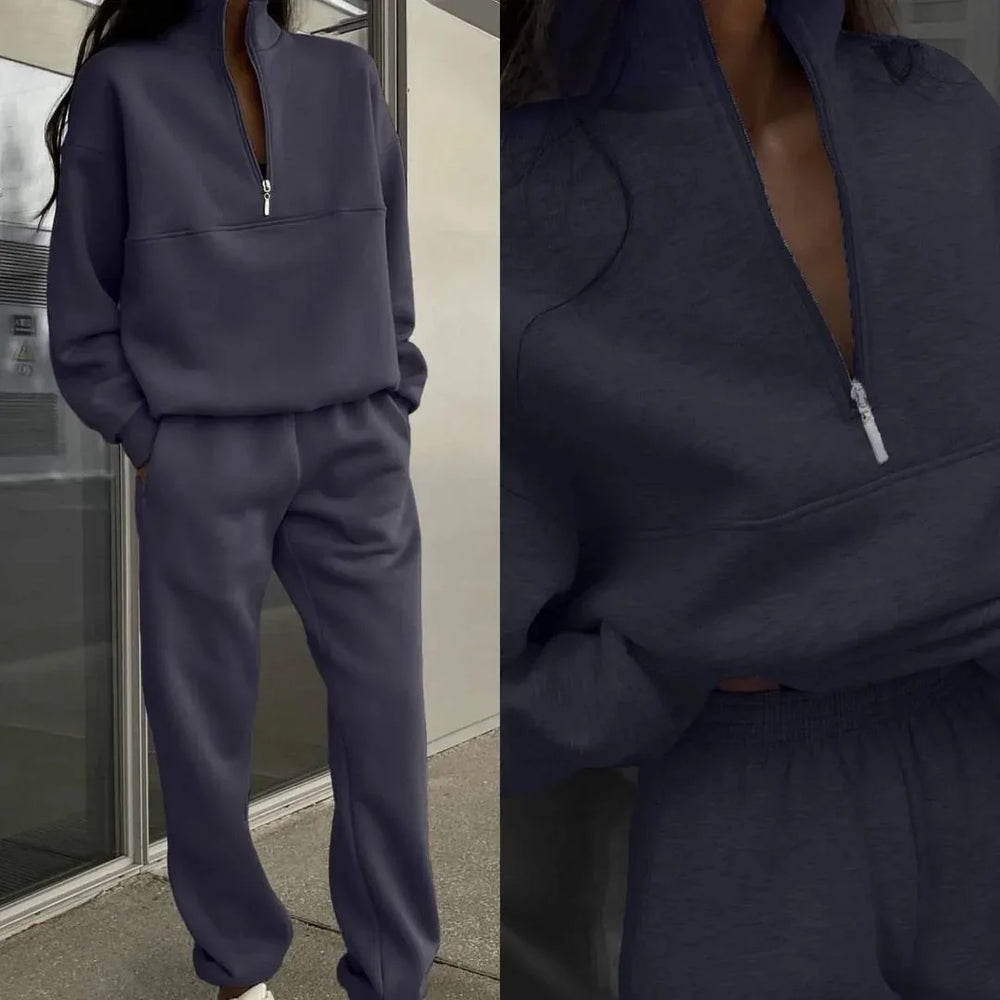 Woman wearing a dark gray zip-up sweatshirt and matching sweatpants loungewear set
