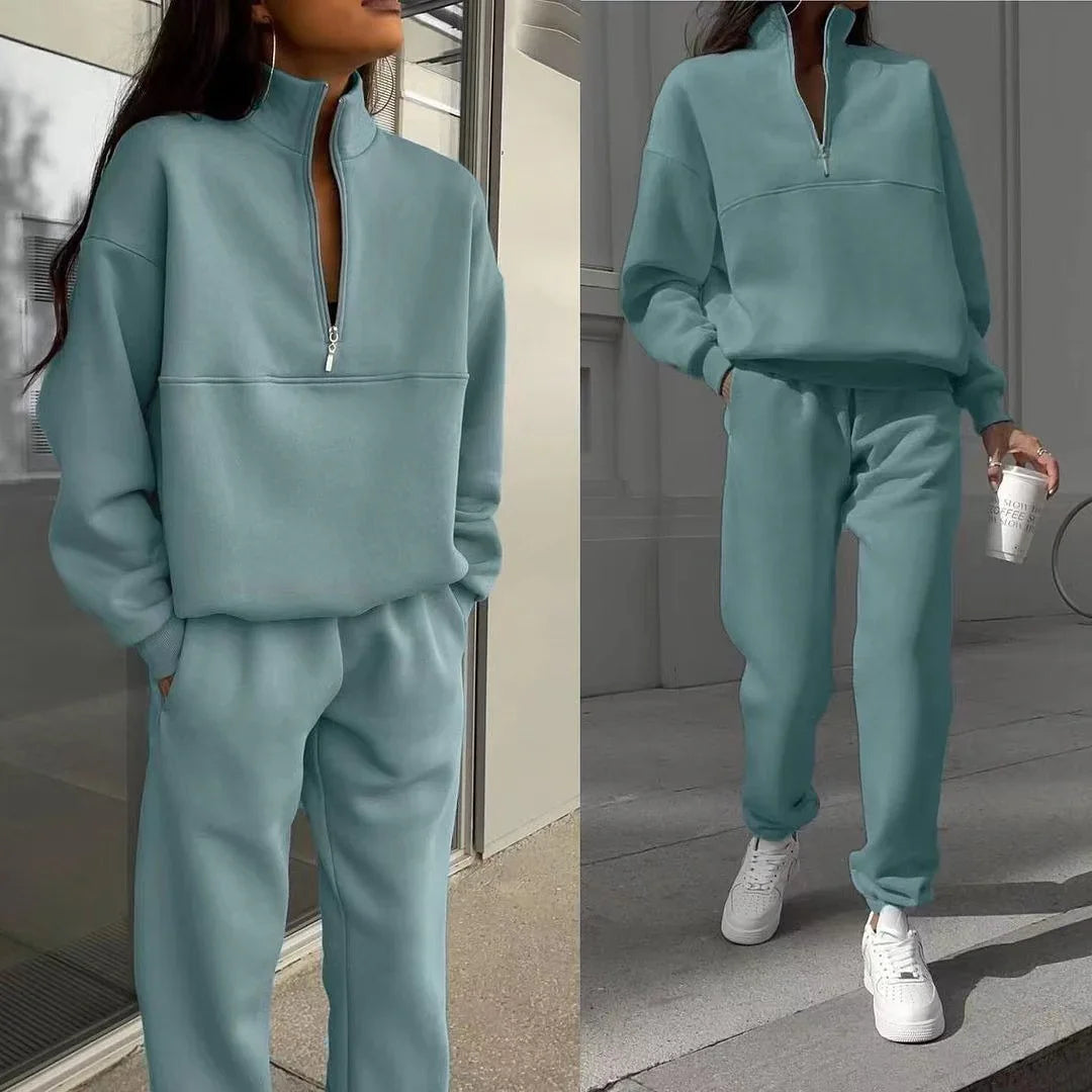 Two views of a woman wearing a light blue zip-up sweatshirt and matching jogger pants with white sneakers