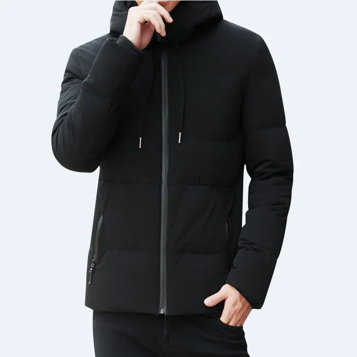 Man wearing black padded winter jacket with hood and zippered pockets