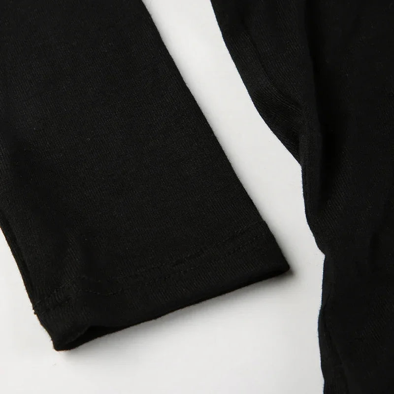 Close-up of black fabric sleeves with hem stitching on white background, soft cotton knit texture