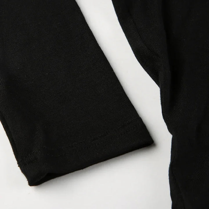 Close-up of black fabric sleeves with hem stitching on white background, soft cotton knit texture