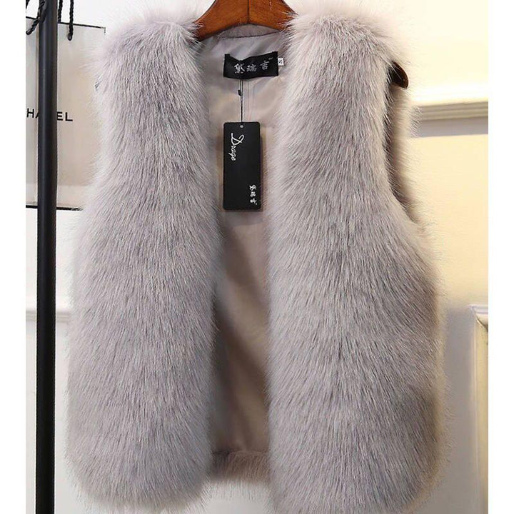 Light gray faux fur sleeveless vest on wooden hanger with black brand tag