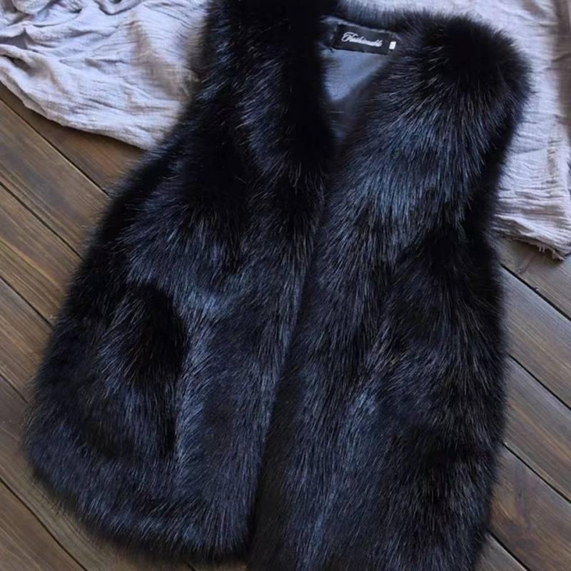 Black faux fur vest with soft texture laid on wooden floor and beige fabric in background