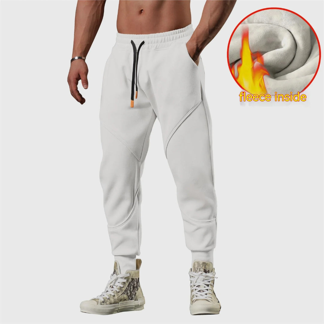 Man wearing white fleece-lined jogger pants with black drawstrings and printed high-top sneakers