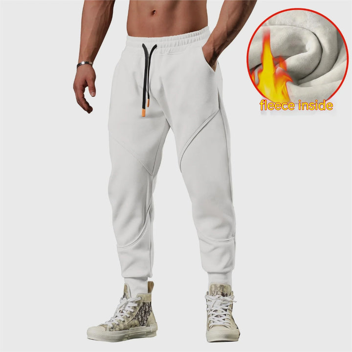 Man wearing white fleece-lined jogger pants with black drawstrings and printed high-top sneakers