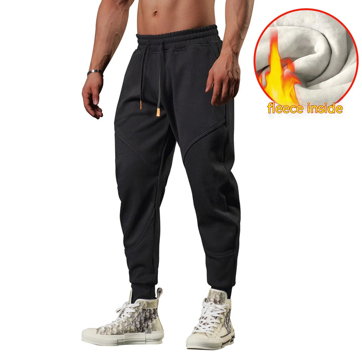 Man wearing black fleece-lined jogger pants with ankle cuffs and white high-top sneakers