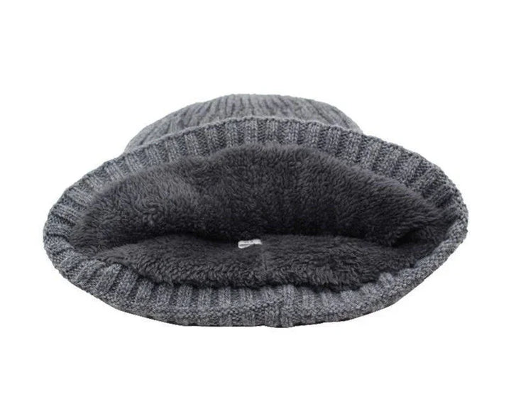 Grey knit beanie hat with soft fleece lining interior, cozy winter accessory isolated on white