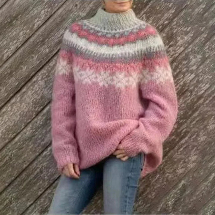 Person wearing a cozy pink and gray knit sweater with a patterned yoke, paired with blue jeans
