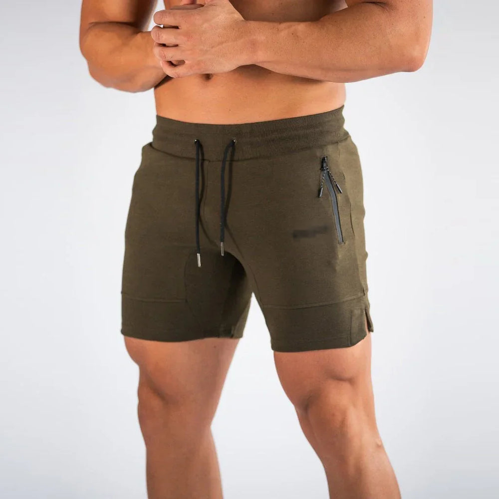 Muscular man wearing olive green athletic shorts with zippered pocket and black drawstrings