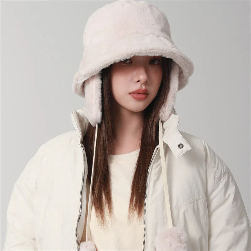 Young woman wearing beige faux fur trapper hat with ear flaps and cream puffer jacket