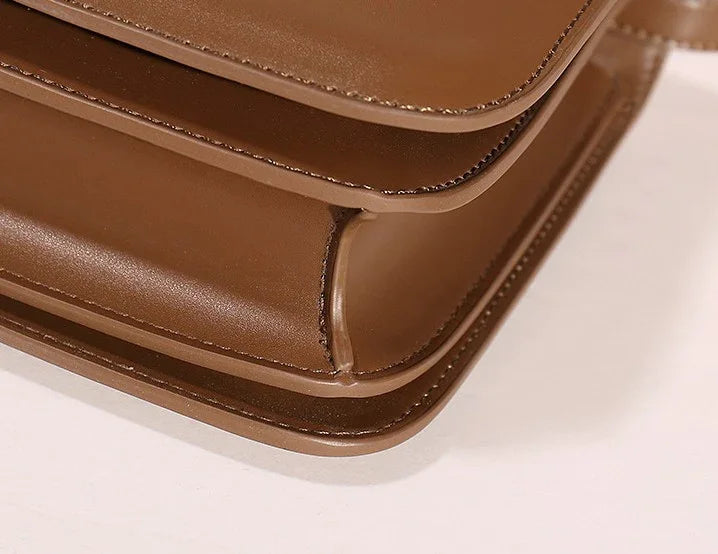 Close-up of brown leather bag corner showing smooth texture and precise stitching
