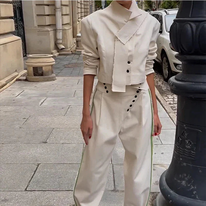 Woman wearing stylish cream cropped jacket and high-waisted wide-leg pants with button details on city street