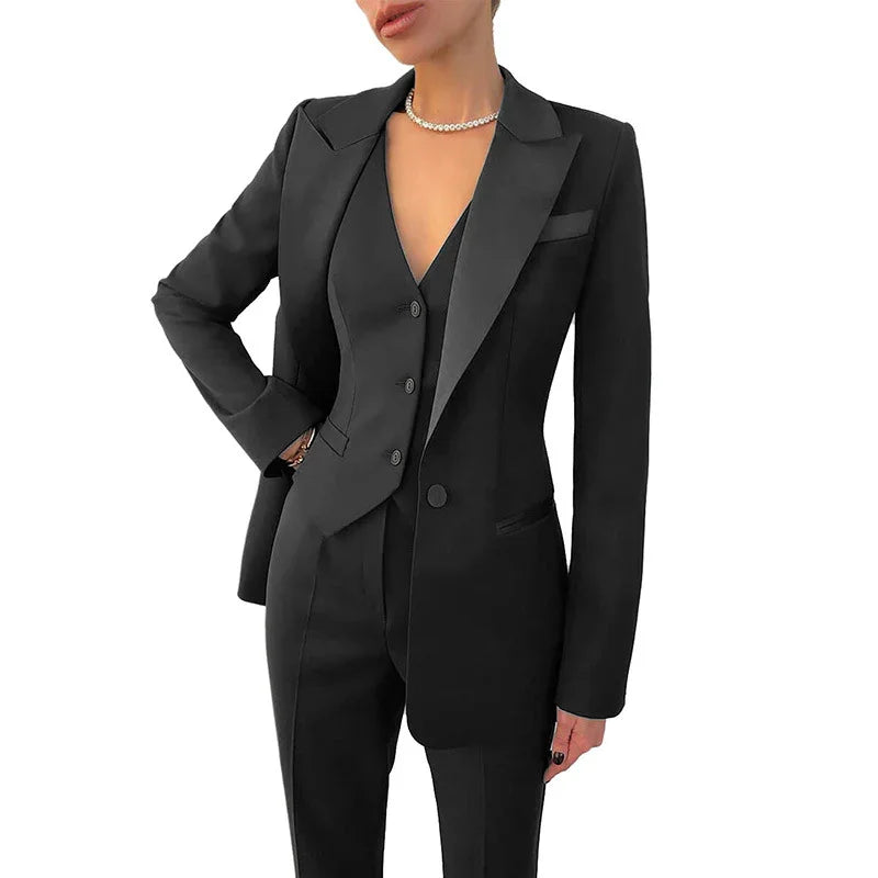 woman wearing a tailored black suit with blazer, vest, and trousers, accessorized with a pearl necklace